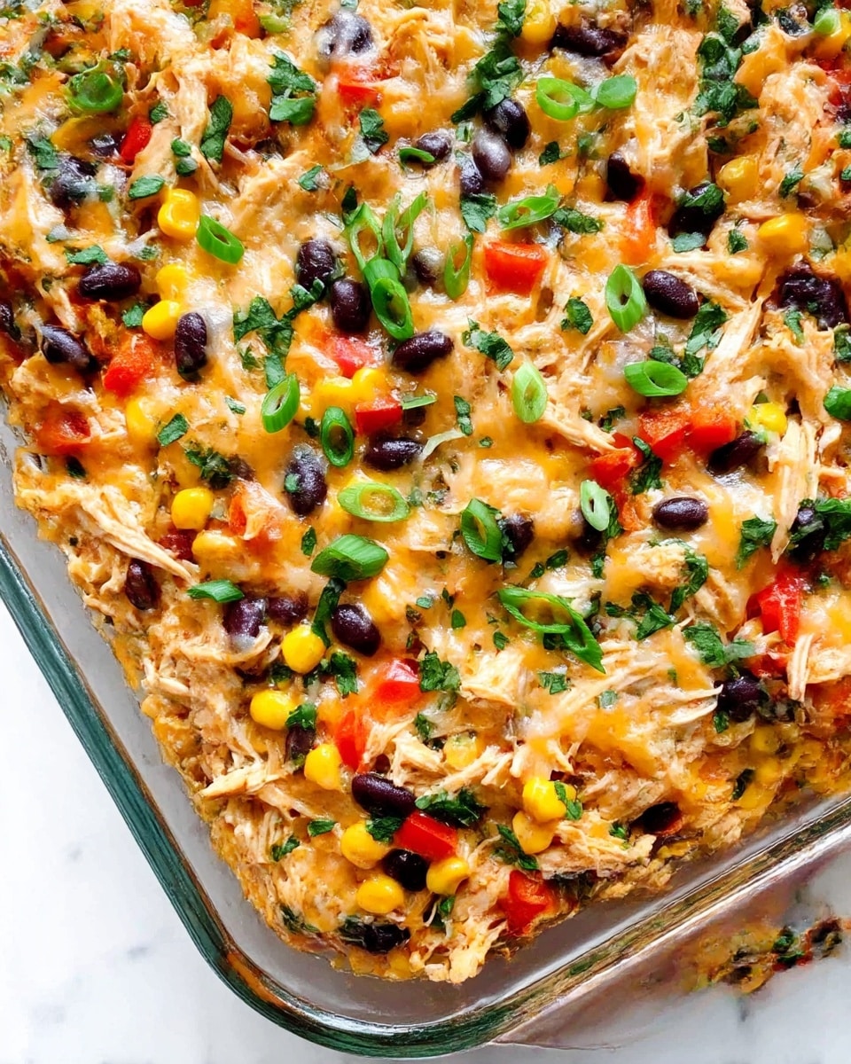 A clear glass baking dish filled with a mixed casserole that has three main visible layers: a shredded chicken base with a warm light brown color, topped with patches of yellow corn, red bell pepper pieces, and black beans scattered evenly; the whole surface is covered with melted cheese that looks soft and slightly browned in parts, with green chopped herbs sprinkled on top for a fresh finish, sitting on a white marbled surface. photo taken with an iphone --ar 4:5 --v 7