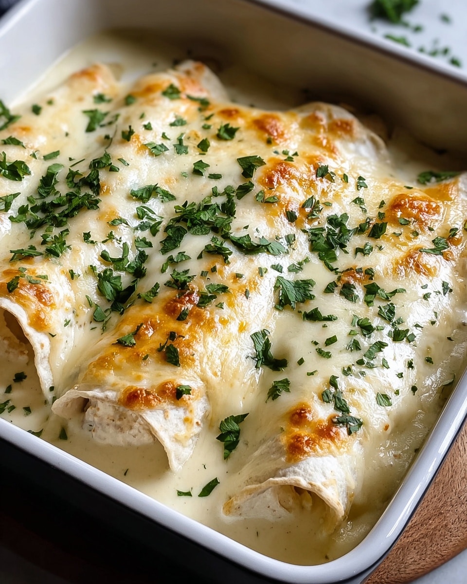 The image shows three rolled tortillas placed side by side in a white baking dish, covered in a creamy white cheese sauce that is bubbly and golden brown on top. Fresh green chopped herbs are sprinkled evenly over the cheese, adding a pop of color. The cheese layer is thick and smooth, partially melted into the tortillas underneath, which look soft and slightly folded at the edges. The white marbled surface under the dish adds a clean and bright background to the warm, cheesy dish. Photo taken with an iphone --ar 4:5 --v 7