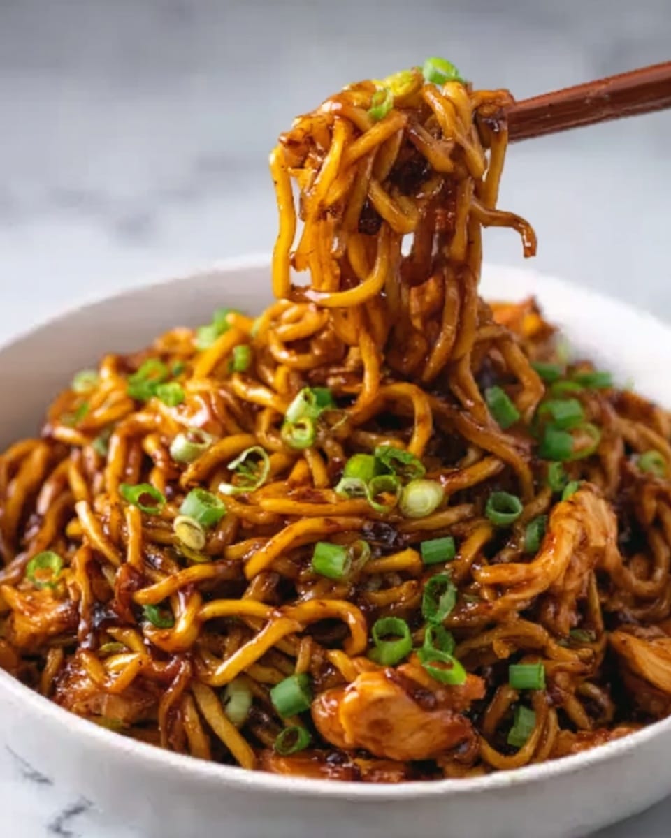 A close-up image of a white bowl filled with dark brown noodles coated in a glossy sauce, mixed with small pieces of cooked chicken and garnished with chopped green onions on top. A woman's hand is lifting a clump of noodles with chopsticks, showing the long, slightly twisted strands. The bowl sits on a white marbled surface. Photo taken with an iphone --ar 4:5 --v 7