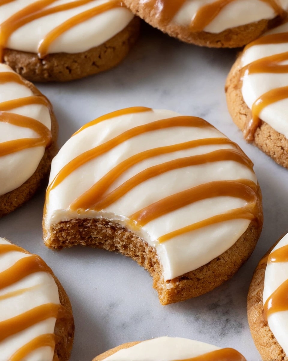 The image shows several round cookies with three visible layers: the bottom layer is a crumbly, light brown cookie base with a rough texture, the middle layer is a thick, smooth white frosting, and the top layer is a shiny caramel drizzle in wavy stripes covering the frosting. One cookie near the center has a bite taken out, revealing the soft inside of the cookie base. The cookies are placed close together on a white marbled surface. Photo taken with an iphone --ar 4:5 --v 7