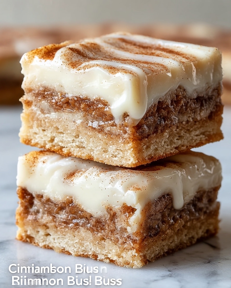 Two stacked cinnamon roll bliss bars with three visible layers each, sitting on a white marbled surface. Each bar has a base layer of light, crumbly dough with a slightly golden-brown color. The middle layer is a darker brown cinnamon filling with a textured, slightly sticky appearance running through the center. The top layer is a thick, creamy icing with swirls and a smooth shine, dripping slightly down the sides. The top surface shows a dusting of cinnamon that gives a grainy texture along with the icing. The bars are closely stacked, showing the layers clearly from the side. Photo taken with an iphone --ar 4:5 --v 7