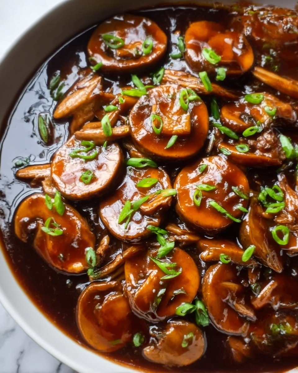 The image shows a dish of glazed mushrooms in a white bowl, with about two main layers: the bottom layer is a dark glossy sauce covering the base, with the top layer made of shiny brown mushroom slices coated in the sauce, sprinkled with small chopped green onions for a splash of color. The mushrooms have a smooth texture and are arranged close together, soaking in the thick sauce that has a rich, reflective surface. The bowl sits on a white marbled surface. Photo taken with an iphone --ar 4:5 --v 7