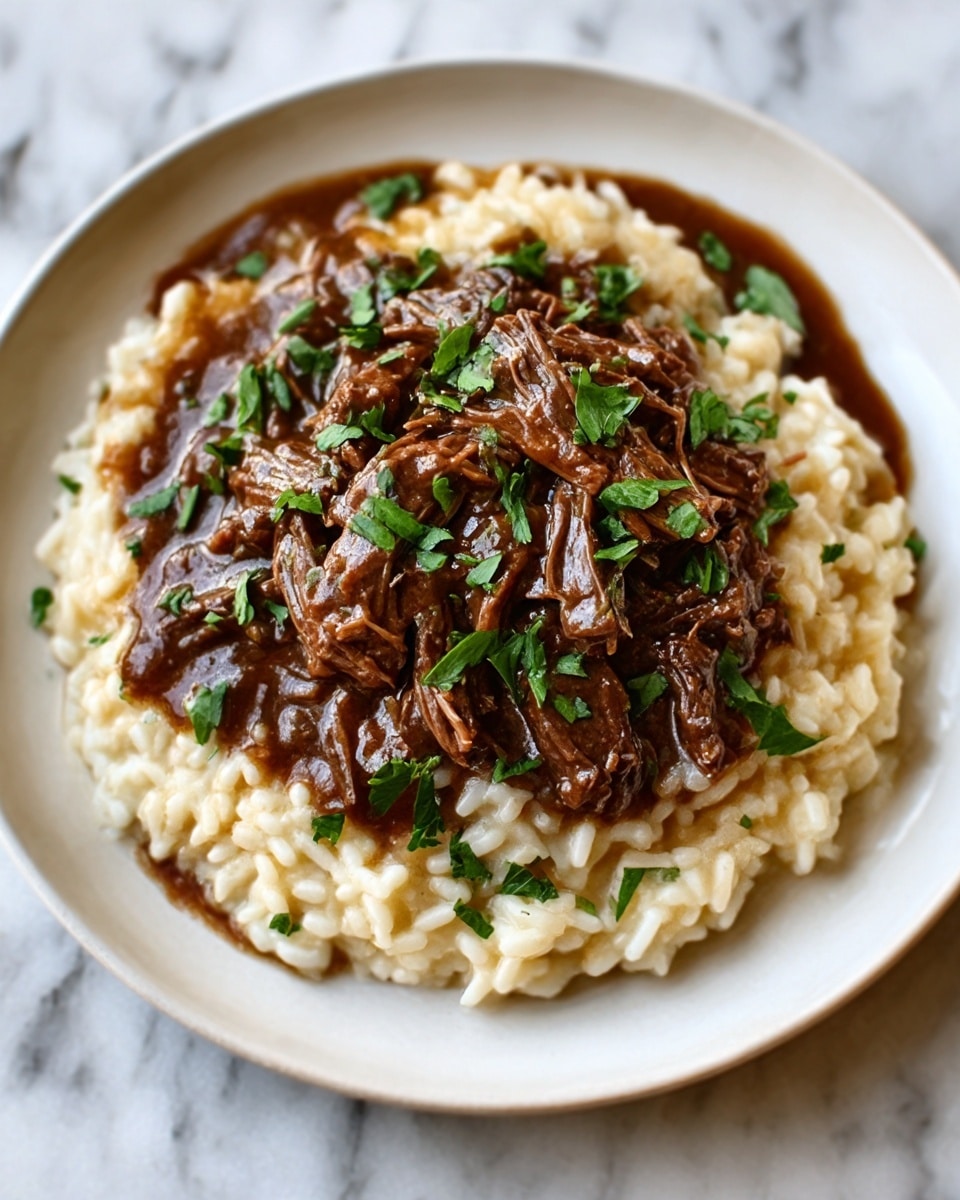 The image shows a white plate filled with creamy risotto, which forms the bottom layer with a soft, smooth texture and light beige color. On top sits a rich, dark brown shredded beef stew with a glossy sauce that looks thick and hearty, covering the middle layer. Bits of green chopped parsley are sprinkled over the beef, adding a pop of fresh color and texture. The plate is placed on a white marble surface, giving a clean and elegant background. Photo taken with an iphone --ar 4:5 --v 7